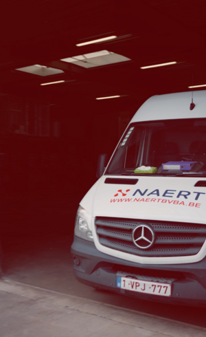 Bestelwagen van Naert in een rood verlichte loods