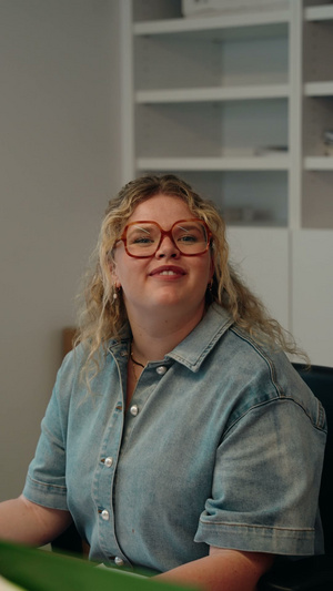 Glimlachende medewerkster van Naert aan haar bureau