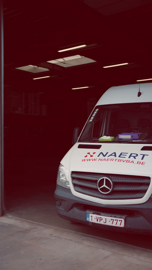 Bestelwagen van Naert in een rood verlichte loods